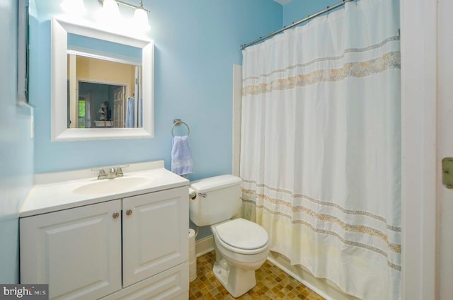 bathroom with toilet, vanity, and a shower with curtain