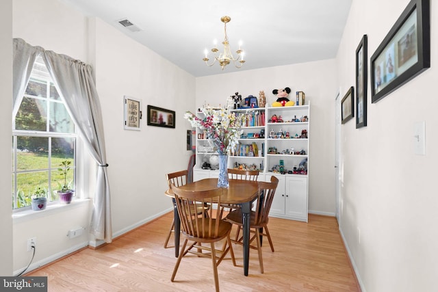 dining area with a chandelier, light wood-style floors, and healthy amount of natural light