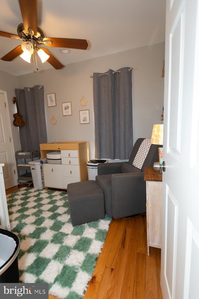 living room with a ceiling fan and wood finished floors