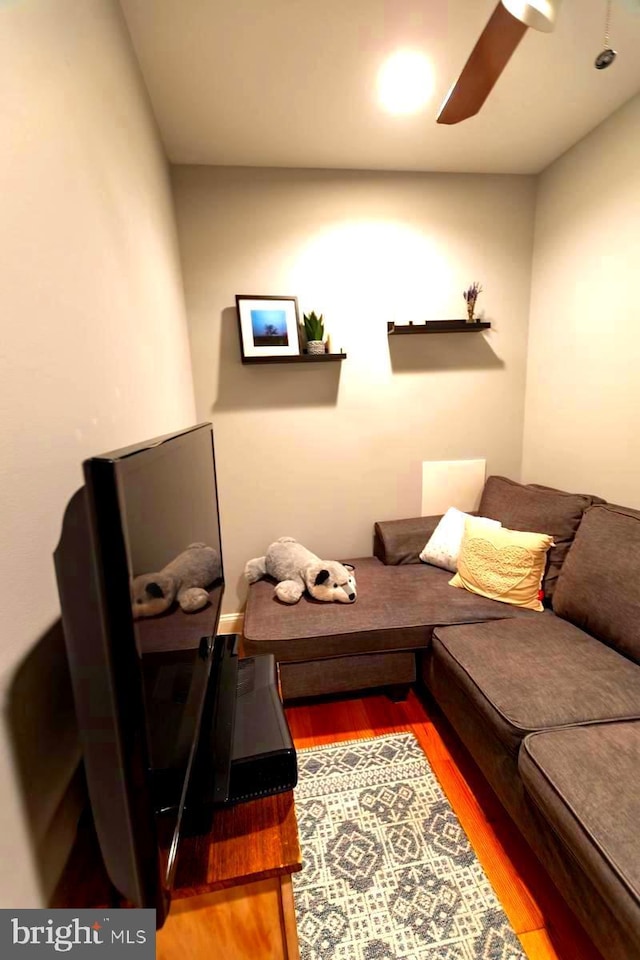 living room with wood finished floors and a ceiling fan