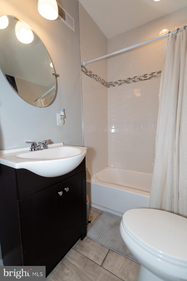 bathroom featuring toilet, shower / bath combo with shower curtain, vanity, and tile patterned floors