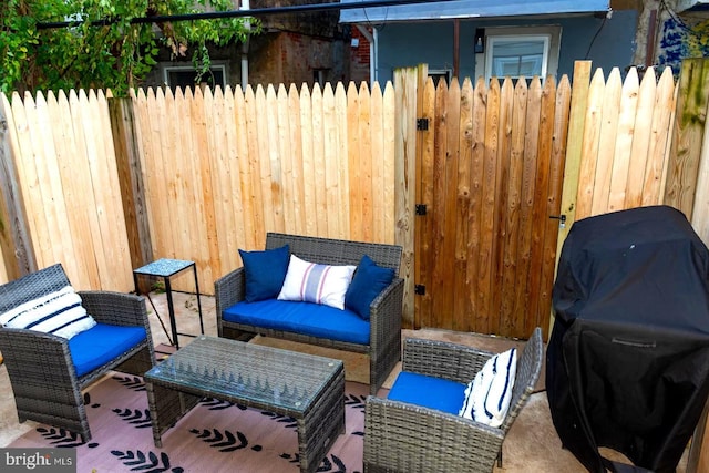 view of patio featuring fence, a grill, and an outdoor hangout area