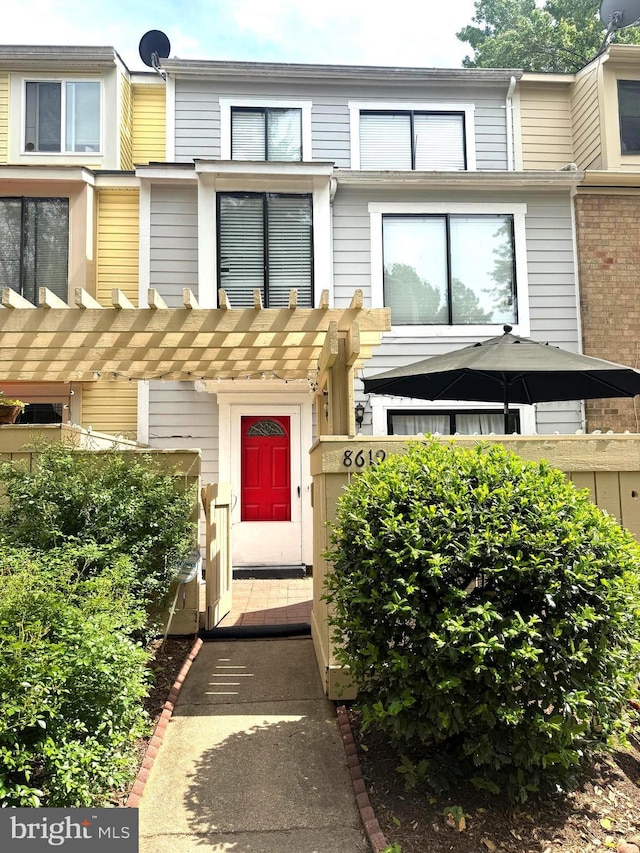 view of exterior entry featuring a pergola