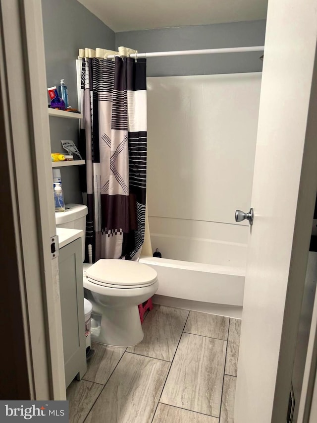 full bath with toilet, shower / bath combo, and vanity