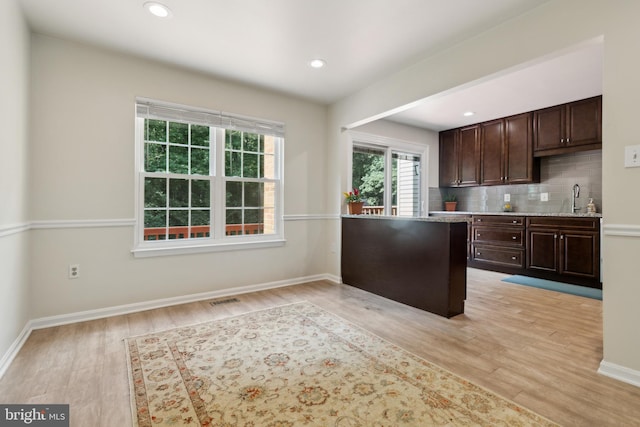 7879 Wintercress Ln, Springfield, VA 22152 - kitchen featuring light wood-style flooring, backsplash, dark brown cabinetry, baseboards, and recessed lighting