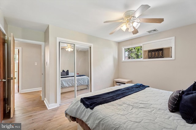 bedroom featuring light wood finished floors, a closet, baseboards, and ceiling fan