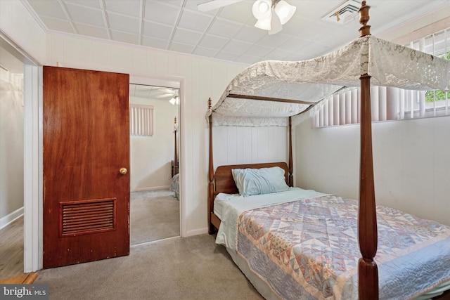 carpeted bedroom with ornamental molding and baseboards