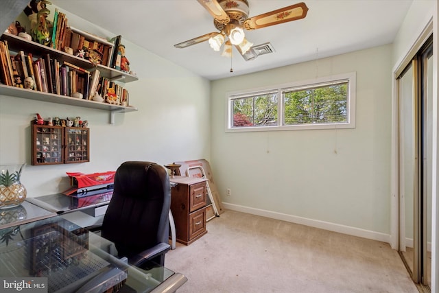office area featuring a ceiling fan, baseboards, and light carpet