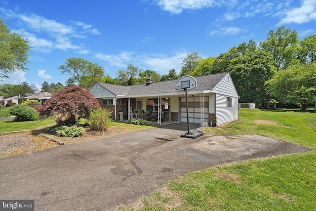 ranch-style home featuring a front lawn, asphalt driveway, brick siding, a shingled roof, and an attached garage