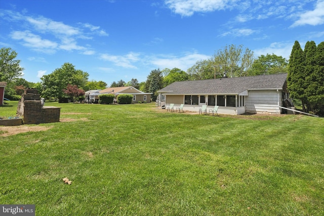 view of green lawn with a sunroom