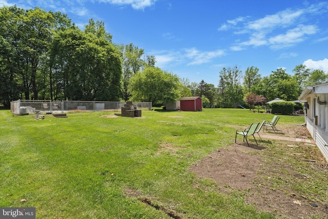 view of yard with a shed, an outdoor structure, and an outdoor fire pit