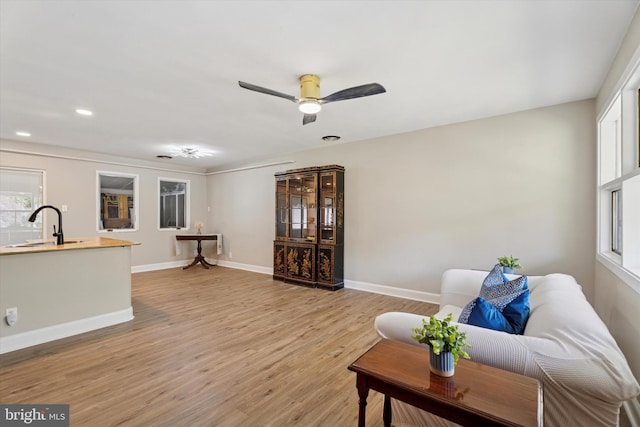 living area with light wood finished floors, healthy amount of natural light, baseboards, ceiling fan, and recessed lighting