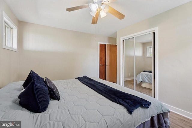 bedroom with wood finished floors, baseboards, a closet, and a ceiling fan