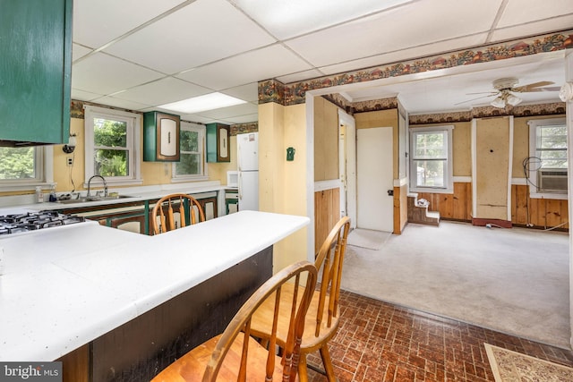 kitchen featuring a sink, light countertops, a ceiling fan, cooling unit, and a paneled ceiling