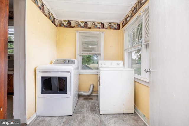 washroom with washer and clothes dryer, plenty of natural light, and baseboards