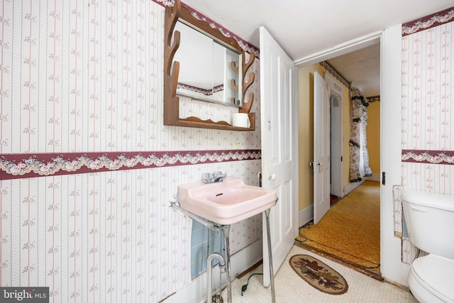 bathroom with wallpapered walls and toilet