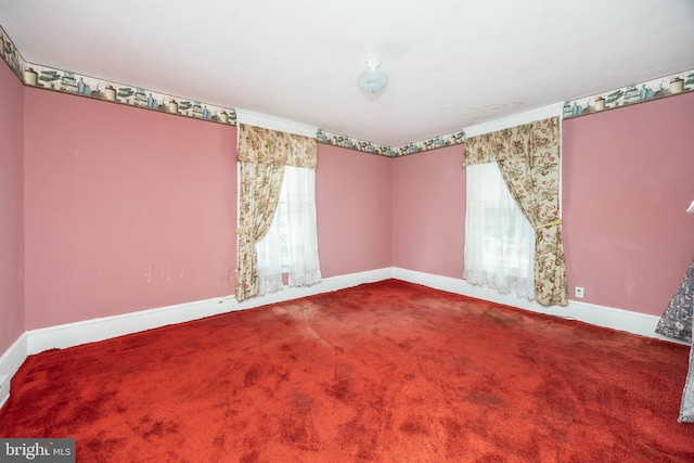 unfurnished room with baseboards and carpet flooring