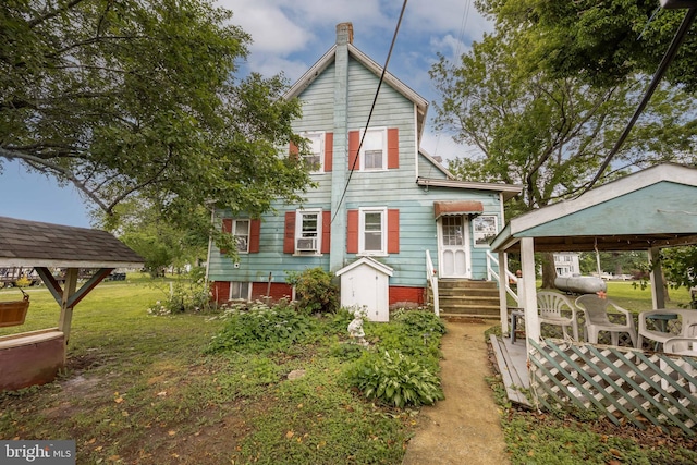 view of front of property with a front lawn, cooling unit, and entry steps