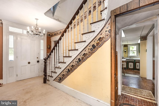 foyer entrance with stairs and a chandelier
