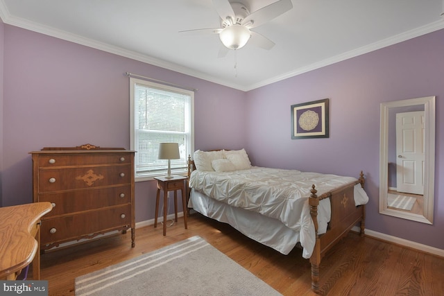 bedroom with wood finished floors, baseboards, ornamental molding, and a ceiling fan
