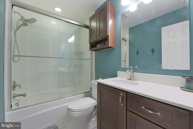 bathroom with vanity, toilet, and bath / shower combo with glass door
