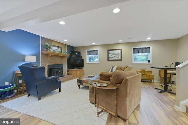 living room featuring light wood-style flooring, healthy amount of natural light, recessed lighting, baseboards, and a fireplace