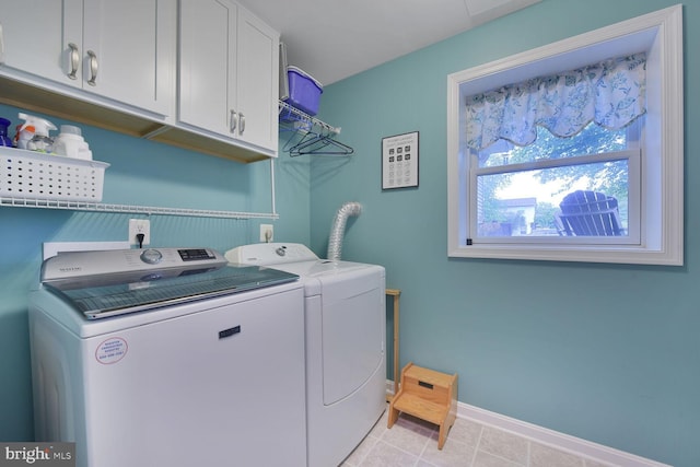 washroom featuring separate washer and dryer, cabinet space, baseboards, and light tile patterned floors