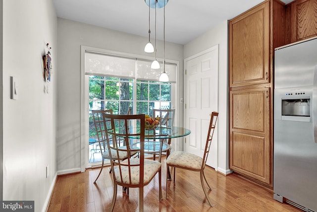 dining area with baseboards and light wood finished floors