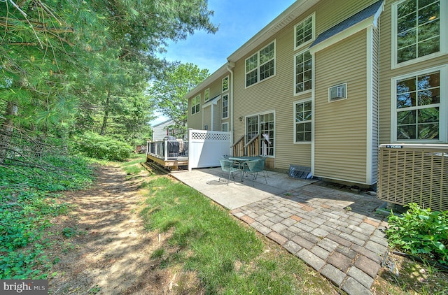 rear view of property with a patio area, central AC, and a wooden deck
