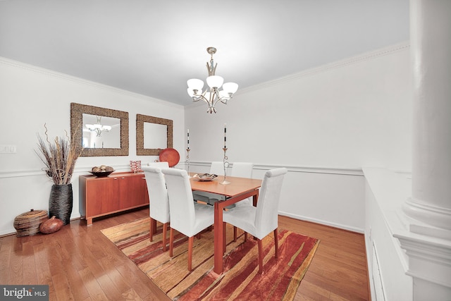 dining space featuring a chandelier, light wood-type flooring, and ornamental molding