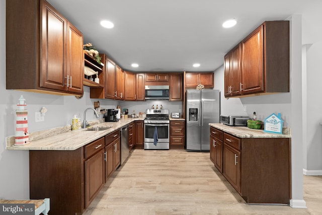 kitchen featuring stainless steel appliances, a sink, light wood-type flooring, recessed lighting, and open shelves
