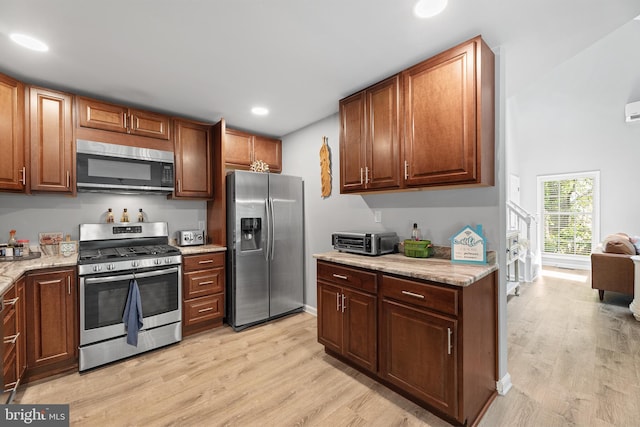 kitchen with stainless steel appliances, light wood finished floors, recessed lighting, and light stone counters