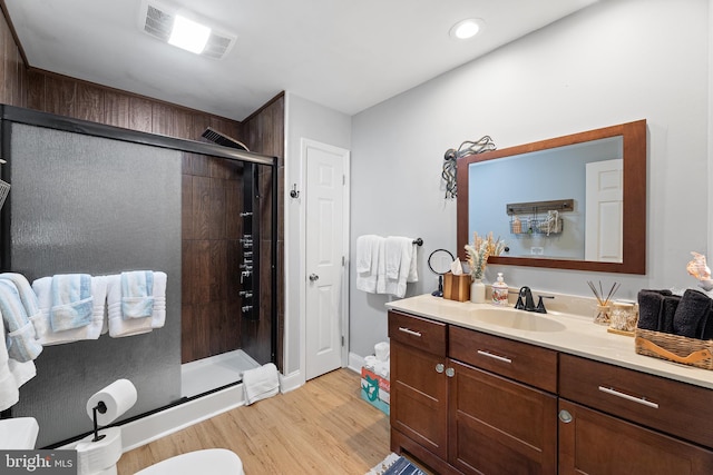 full bath with wood finished floors, a stall shower, vanity, and baseboards