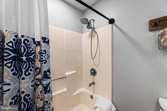 bathroom featuring shower / bathtub combination with curtain and toilet