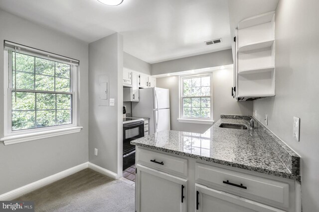 2101 N Taft St Unit 123, Arlington, VA 22201 - kitchen with freestanding refrigerator, range with electric cooktop, light carpet, white cabinets, and light stone countertops