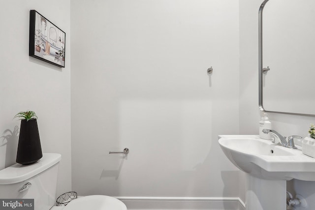 bathroom with toilet and baseboards