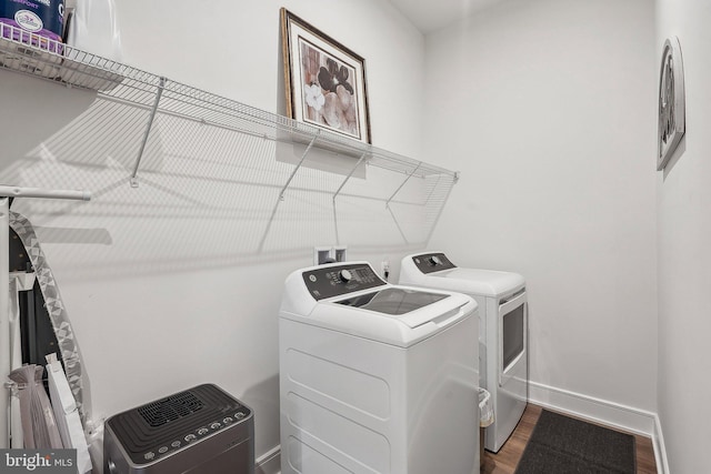laundry area with washer and dryer, wood finished floors, and baseboards