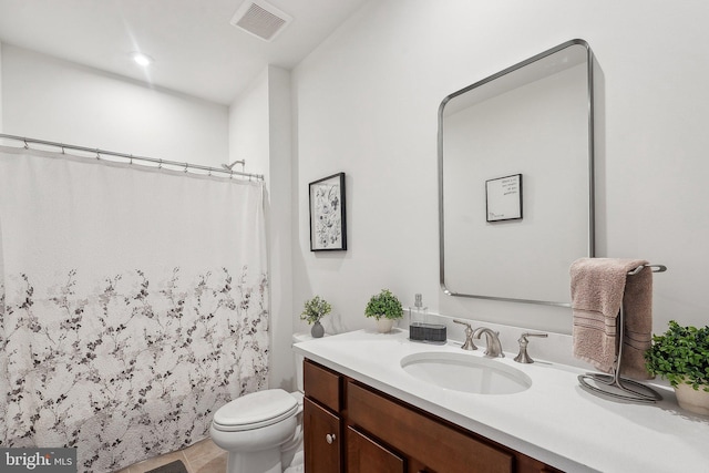 bathroom featuring toilet, vanity, and a shower with curtain
