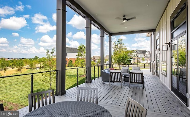 wooden terrace with ceiling fan, an outdoor hangout area, outdoor dining area, a yard, and a residential view