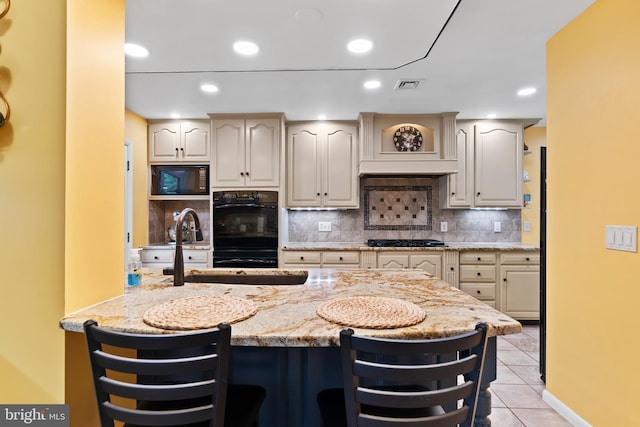 115 Diller Rd, New Cumberland, PA 17070 - kitchen featuring black appliances, light stone countertops, light tile patterned floors, a kitchen bar, and recessed lighting
