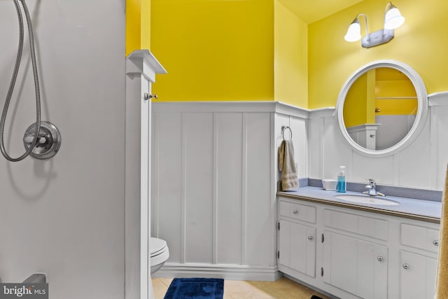 115 Diller Rd, New Cumberland, PA 17070 - bathroom featuring a decorative wall, wainscoting, tile patterned flooring, vanity, and toilet
