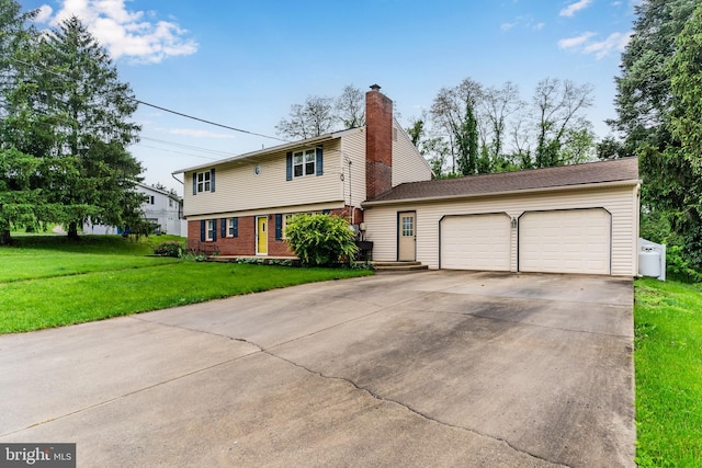 115 Diller Rd, New Cumberland, PA 17070 - colonial inspired home with an attached garage, concrete driveway, a front yard, a chimney, and brick siding