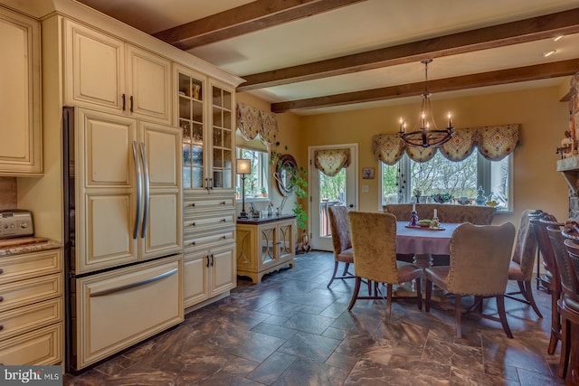 dining space featuring a chandelier, beam ceiling, and stone tile flooring