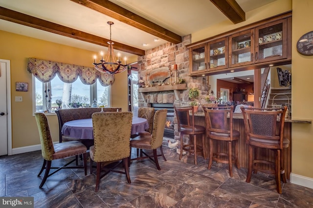dining space with a chandelier, beam ceiling, and baseboards