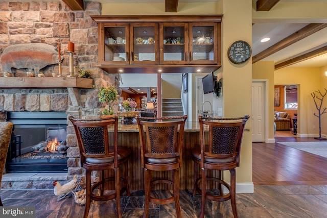 bar area with baseboards, beamed ceiling, and stairway