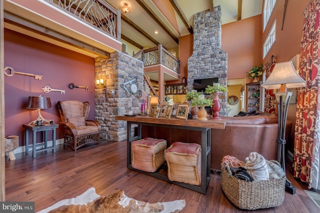 interior space with a towering ceiling, wood finished floors, and beam ceiling