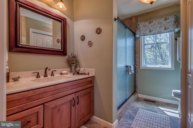 full bath featuring a shower stall, baseboards, vanity, and toilet