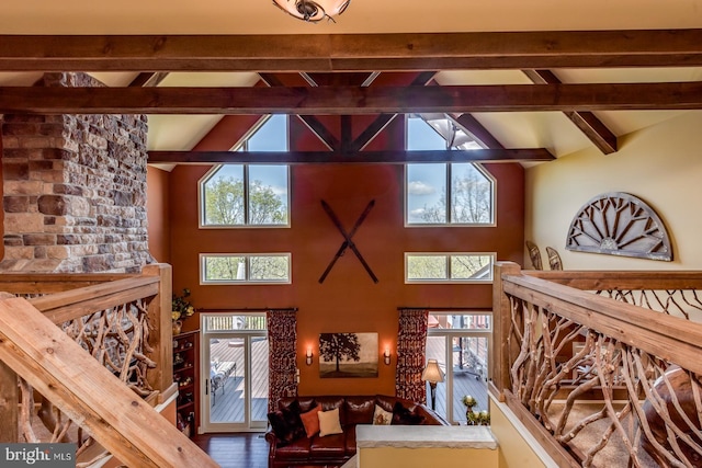 living area featuring beamed ceiling, high vaulted ceiling, and wood finished floors