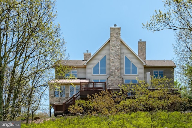 back of property featuring a chimney and a wooden deck