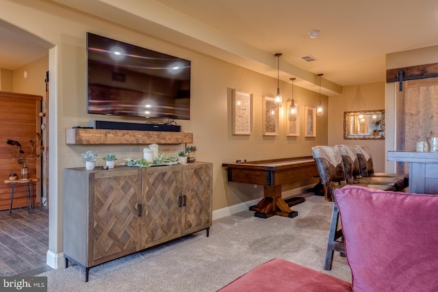bar featuring baseboards, hanging light fixtures, wood finished floors, and carpet